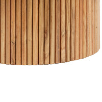 Close-up of fluted wooden coffee table edge featuring vertical carved wood detailing and natural texture.