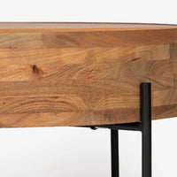 Close-up of round wooden coffee table side edge and black metal leg