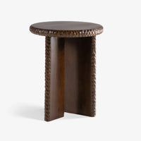 Nashi round wooden side table with sculptural three-sided base and carved textured border.