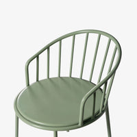 Close-up of green outdoor table edge and curved metal frame