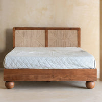 Solid wood bed with woven geometric headboard and rounded wooden legs