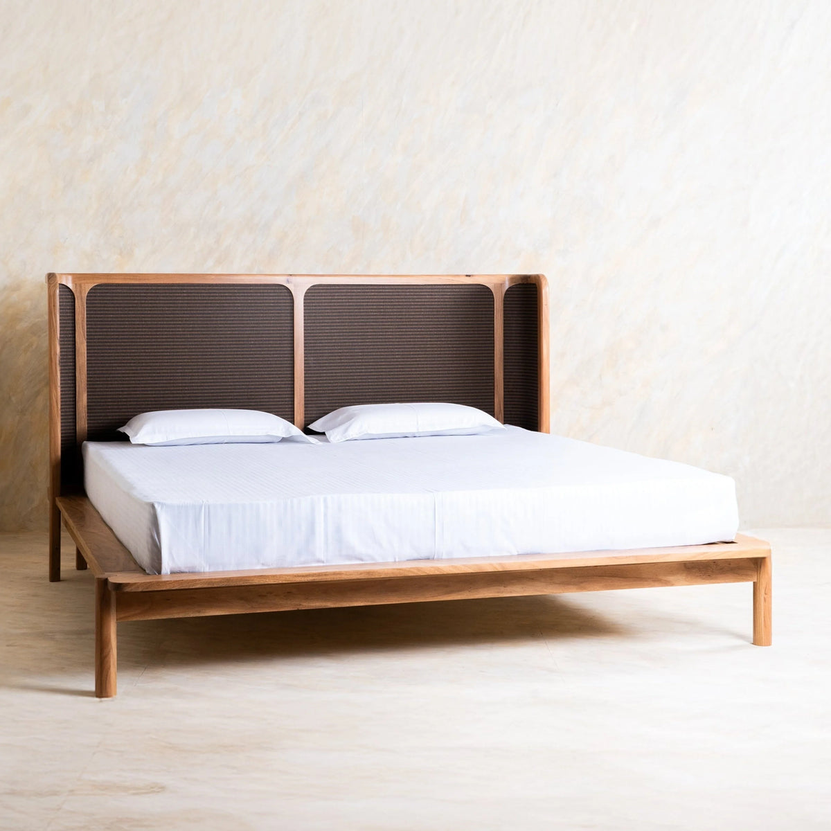  Wooden bed with dark woven panel headboard and natural wood frame.