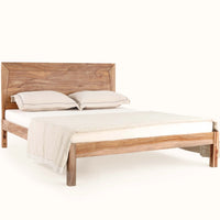 Front angled view of wooden bed with natural wood headboard and upholstered mattress