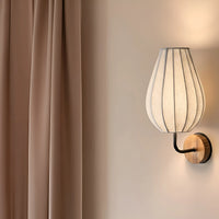 Modern fabric wall sconce with wooden wall mount and warm ambient lighting