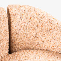 Close-up of textured beige boucle fabric on accent chair