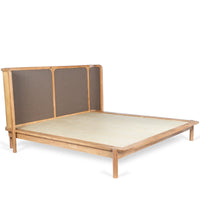 Side view of wooden bed with woven headboard and natural wood platform frame
