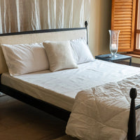 Black metal bed with white bedding styled in a bright modern bedroom interior