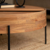 Close-up of round wooden coffee table edge and black metal table leg