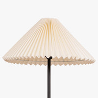 Close-up of pleated cream fabric lampshade on a modern floor lamp