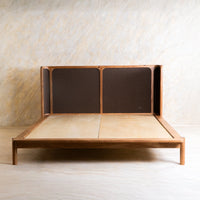 Front view of wooden bed with dark woven headboard and solid wood legs