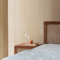 Natural wooden bed with woven headboard and matching bedside table