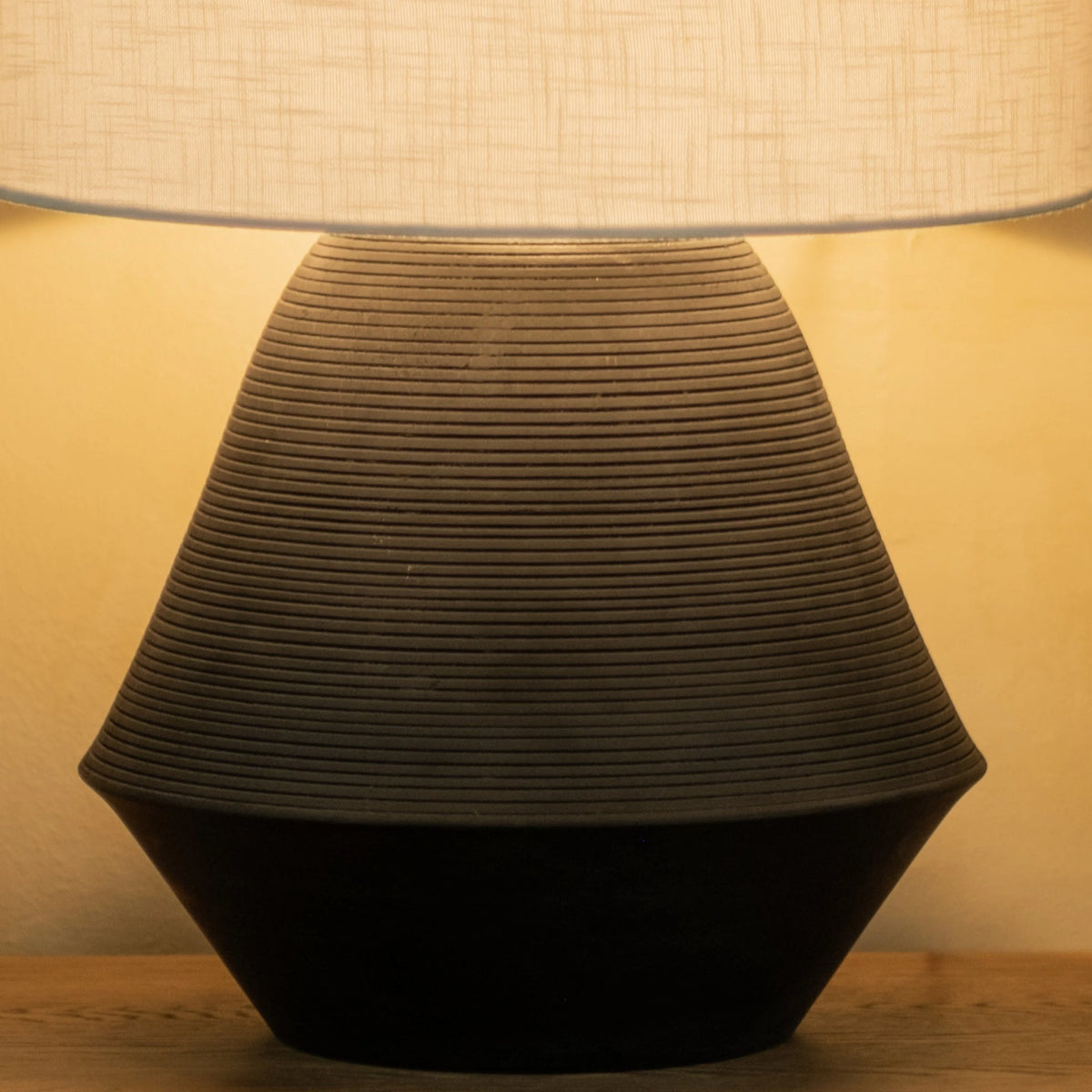 Close-up of textured black table lamp base with ribbed surface design