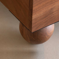 Close-up of rounded wooden bed leg and solid wood frame detail