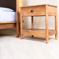 Back view of wooden bedside table with drawer and lower storage shelf