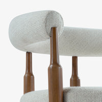 Close-up of curved cream fabric backrest and wooden chair frame