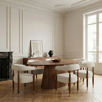 Round wooden dining table with pedestal base in a modern luxury dining room