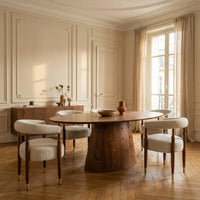 Round wooden dining table with pedestal base in an elegant dining room