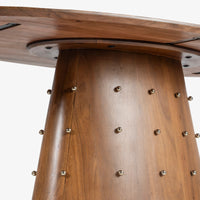 Close-up of wooden dining table pedestal base with decorative metal accents
