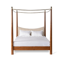 Front view of natural wooden canopy bed with tall posts and curved canopy rails